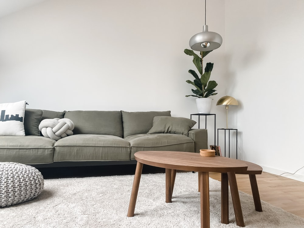 A Home Interior Featuring Engineered Lighting, Organic Tables, Gray-green Furniture, and Other Features of the Scandinavian Style Movement