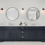 A Bathroom Vanity with Two Sink Bowls, Two Mirrors, a Marble Countertop, and Black Drawers and Cabinets