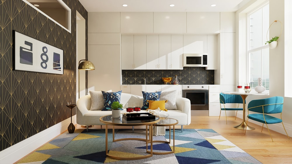 A Room Featuring a White Sofa with Colorful Throw Pillows, White Kitchen Cabinets, a Blue Coffee Table Set, and a Colorful Rug