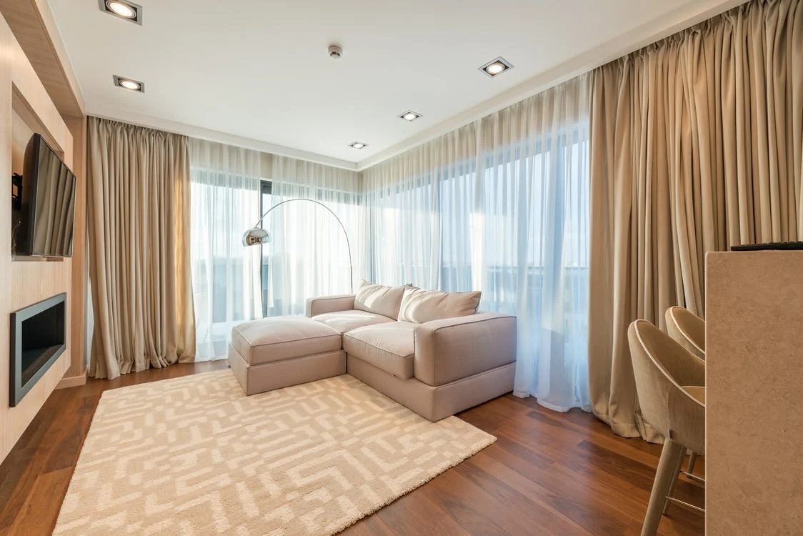  a warm beige living room with an L-shaped sofa